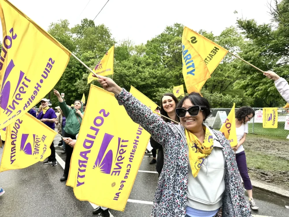 Mary-Murphy Walsh, a labor organizer with SEIU 1199, leads Butler Hospital workers in a single-file march during an informational picket on Monday, April 21, 2025, amid ongoing contract negotiations with employer Care New England.