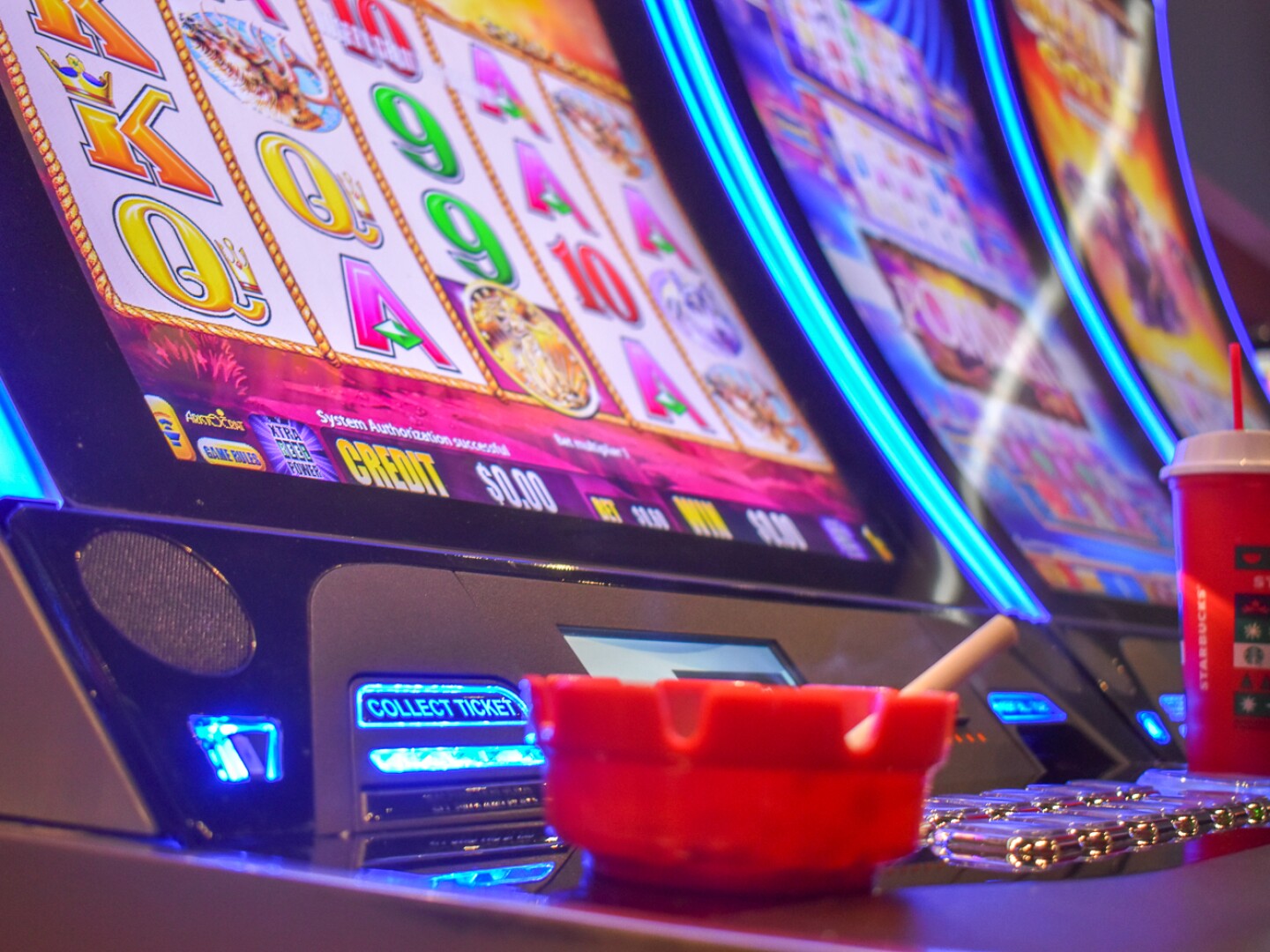 A lit cigarette rests in an ashtray by a slot machine at Bally’s Twin River Lincoln in 2023.