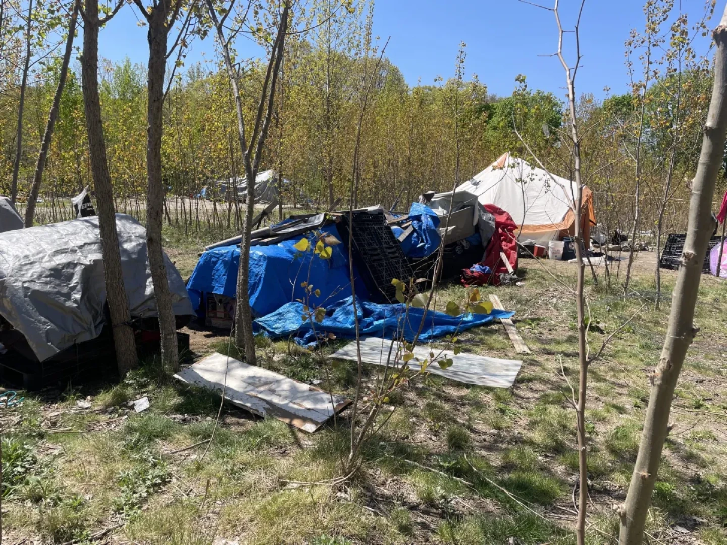 Tarps cover an electric generator and spare supplies at an encampment in Providence. The white tent in the background serves as a community kitchen with canned goods and a microwave.