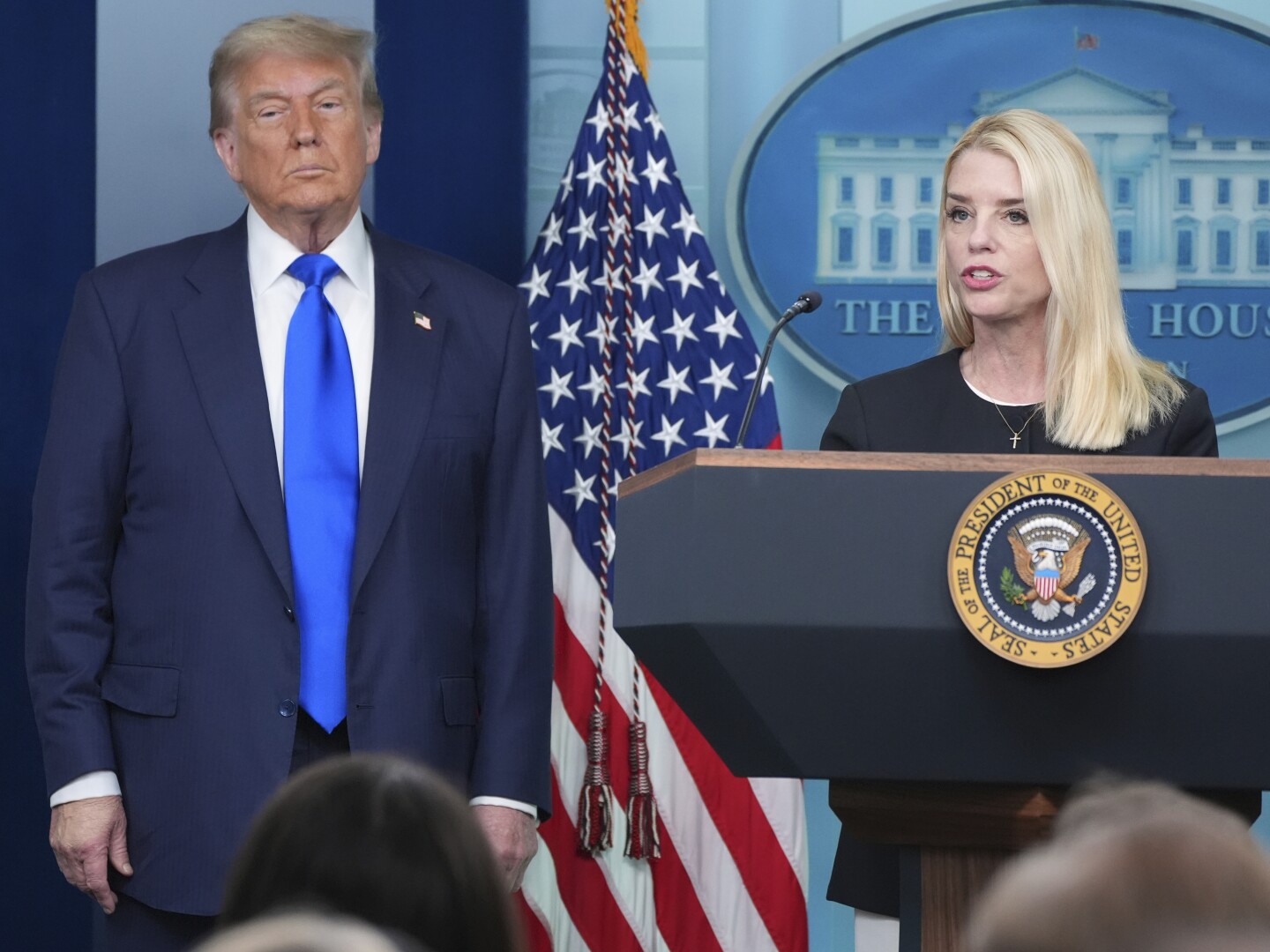 Attorney General Pam Bondi speaks to reporters as President Donald Trump listens, Friday, June 27, 2025, in the briefing room of the White House in Washington.