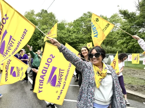 Health care workers strike in the rain.