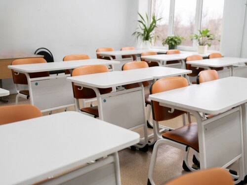 back to school concept, empty classroom with white tables and chairs