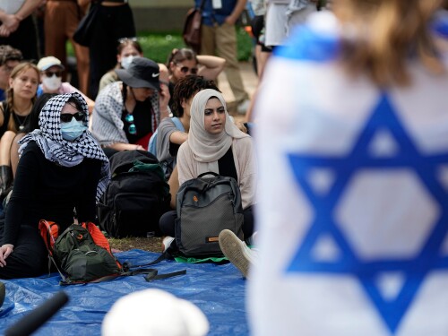FILE - A student wrapped in an Israeli flag listens to Pro-Palestinian protesters gathered on campus at the University of Texas at Austin, on April 30, 2024, in Austin, Texas. (AP Photo/Eric Gay, File)