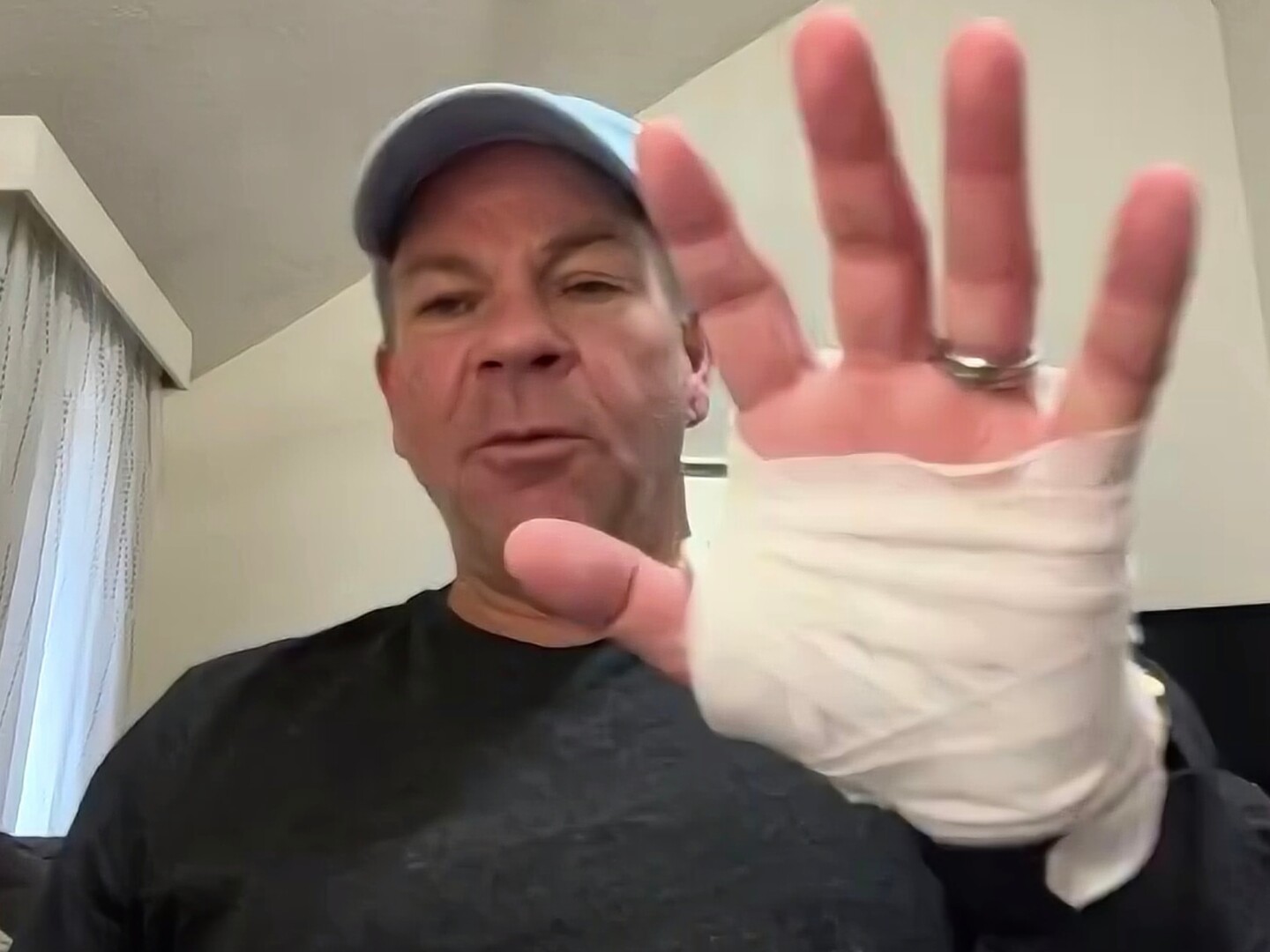 In this image taken from video, Michael Black, a Rhode Island man who helped stop a shooter at a high school hockey game on Monday, holds up his injured hand during an interview with The Associated Press, Thursday, Feb. 19, 2026 in Spartanburg, S.C.