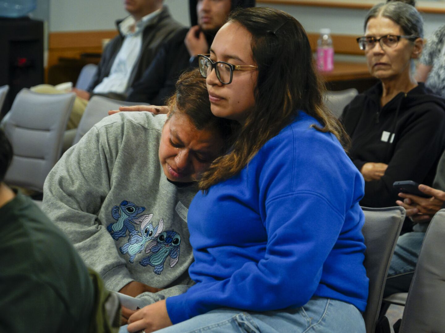 After giving an emotional testimony at the Public Utilities Commission hearing on winter electric rates on Tuesday, Sept. 9, 2025, Vrenely Espinosa of Woonsocket is consoled by her friend Daisy Paz.