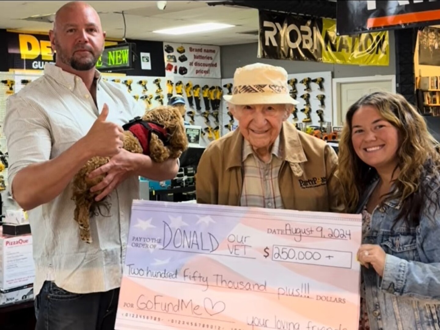 Donald, center, holds a $250,000 check presented to him by TikTok content creator Jenelle Marie on Aug. 9. More than $100,000 has been raised since then.