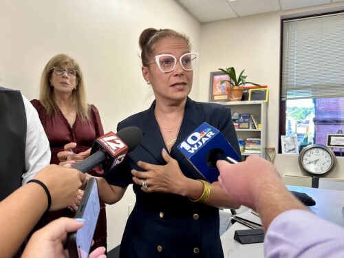 Angélica Infante-Green speaks with reporters after the Aug. 29 meeting.