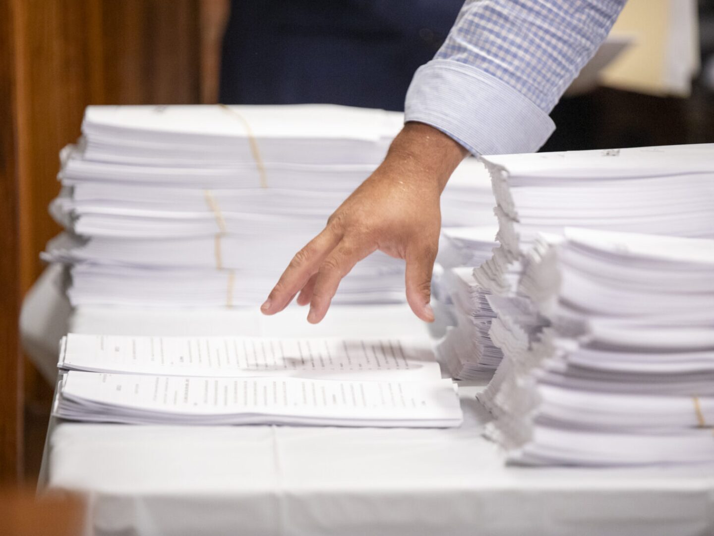 House staff arrange articles from the chamber’s version of the fiscal 2026 budget during a House Committee on Finance meeting on the evening of June 10, 2025.