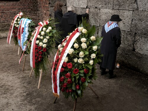 A survivor stands after placing a candle to the Death Wall at the Auschwitz-Birkenau former Nazi German concentration and extermination camp, during a ceremony marking the 80th anniversary of the camp's liberation, in Oswiecim, Poland, Monday, Jan. 27. 2025.